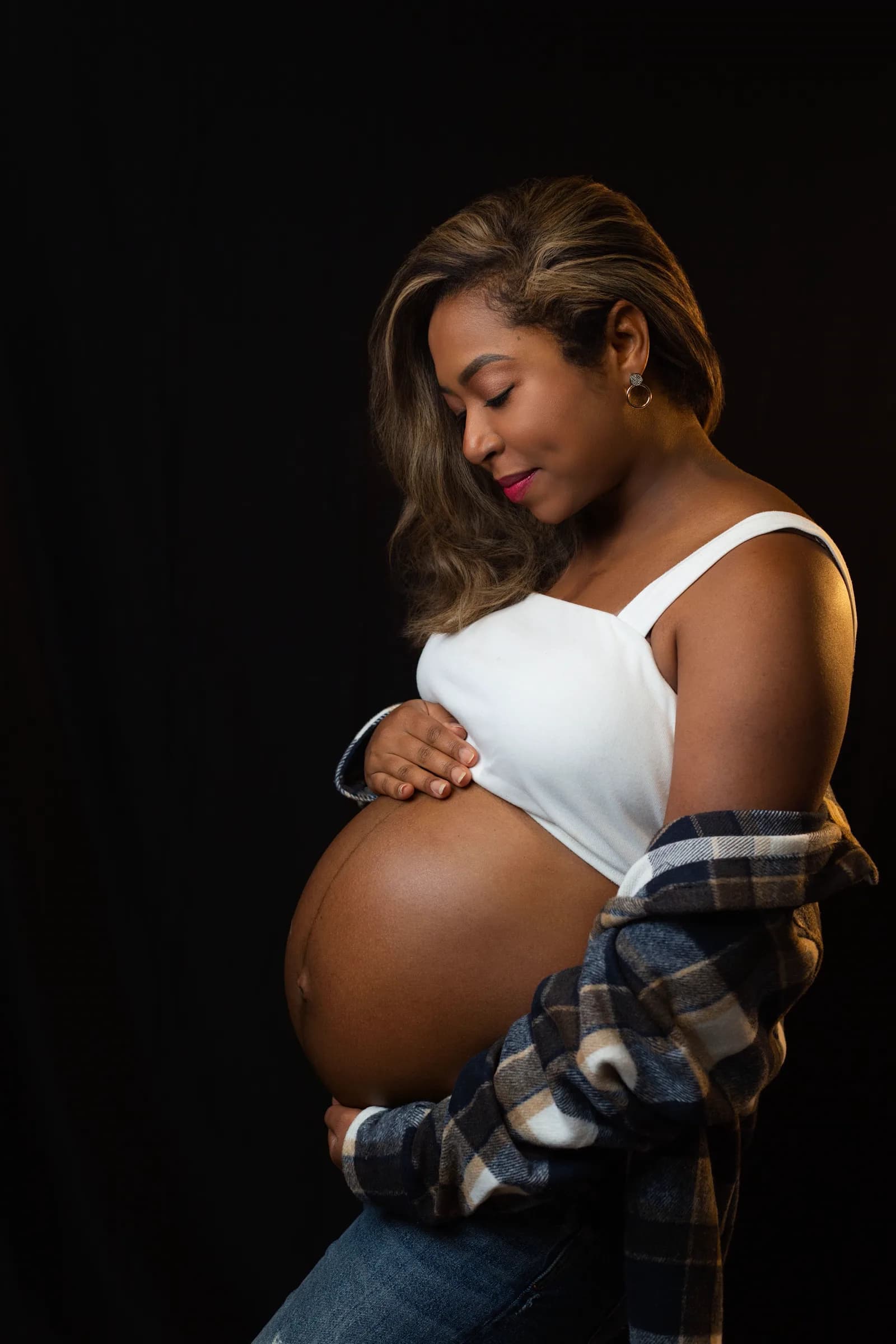 A pregnant woman resting a hand on her belly.